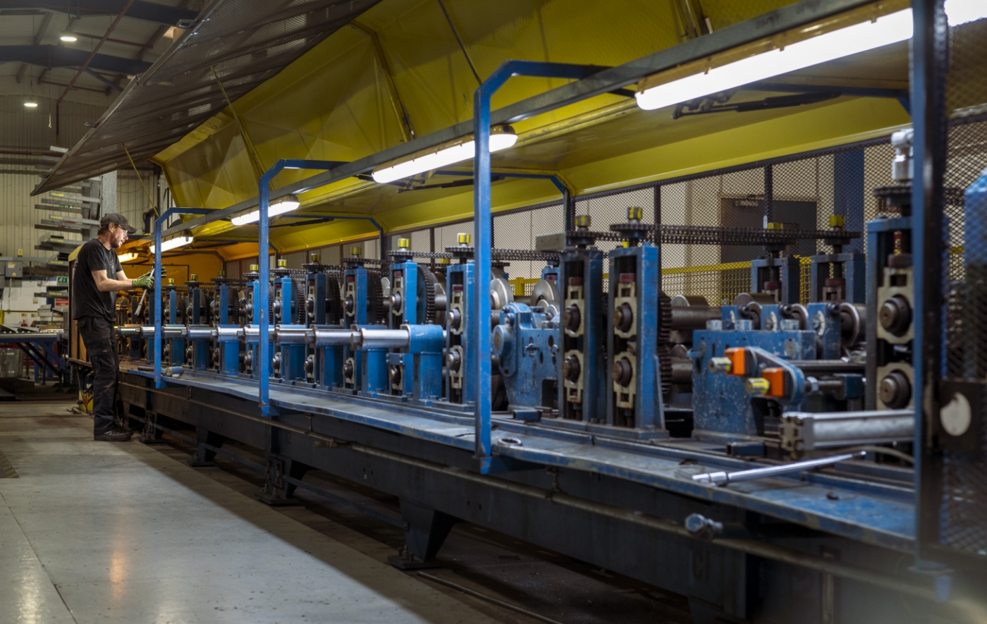 An employee maintaining Fusion's roll forming machine.